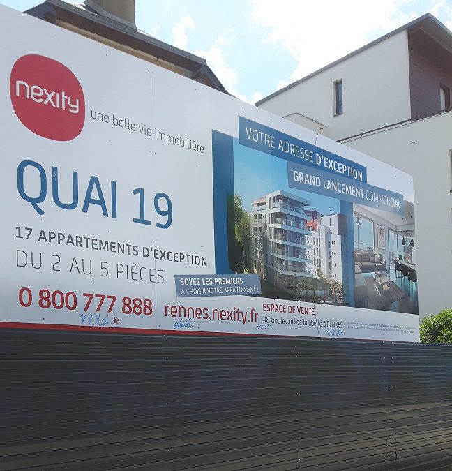 Grand panneau de promotion immobilière avec palissade